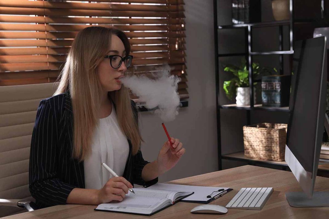 woman vaping in office